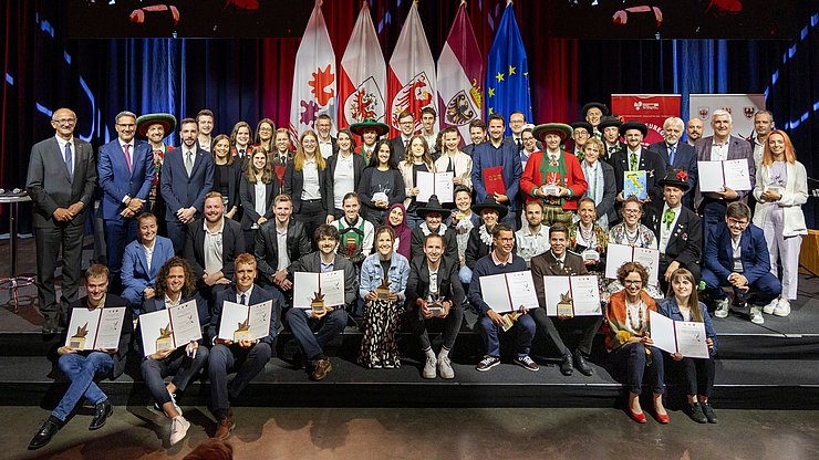 Foto di gruppo con tutti i premiati e gli ospiti d'onore: undici giovani e sette progetti hanno ricevuto oggi il premio "Prestazione d'Eccellenza - il volontariato giovanile" da parte del Tirolo, dell'Alto Adige e del Trentino.
