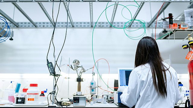 © Pexels/Thisisengineering Wissenschafterin steht in einem Labor und wendet sich einem Bildschirm zu.